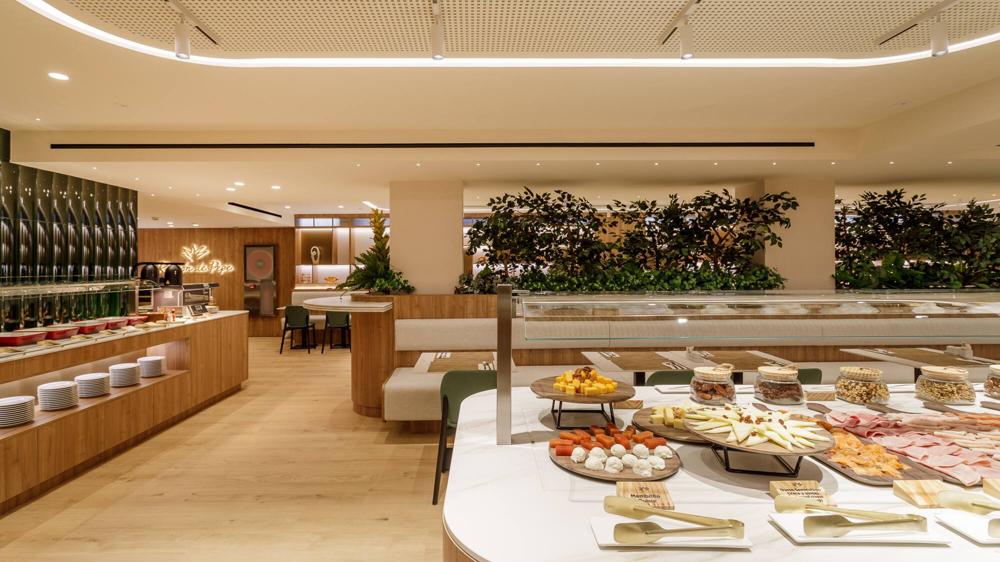 Modern hotel buffet featuring cheeses, meats, nuts, and hot dishes.