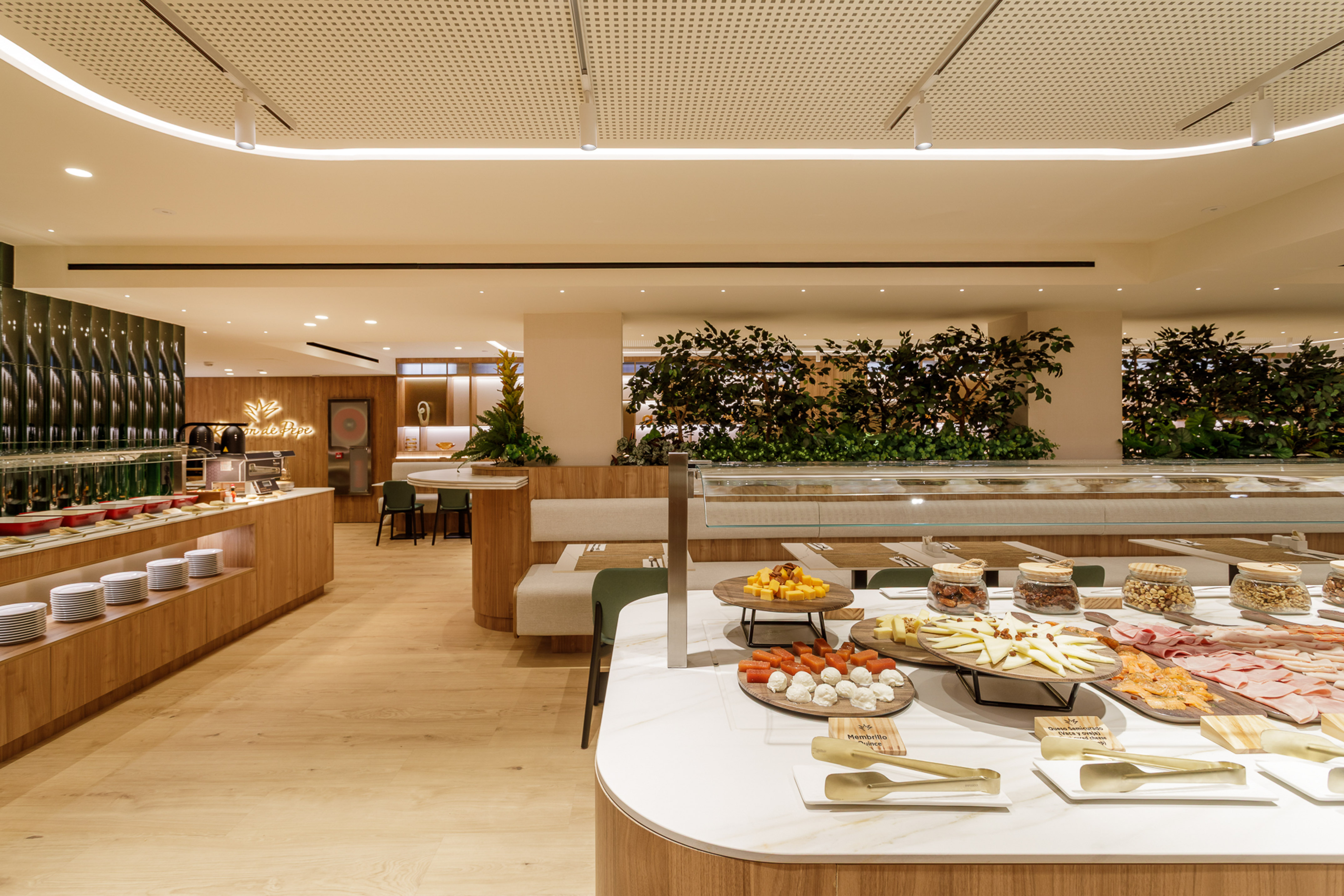 Modern hotel buffet featuring cheeses, meats, nuts, and hot dishes.