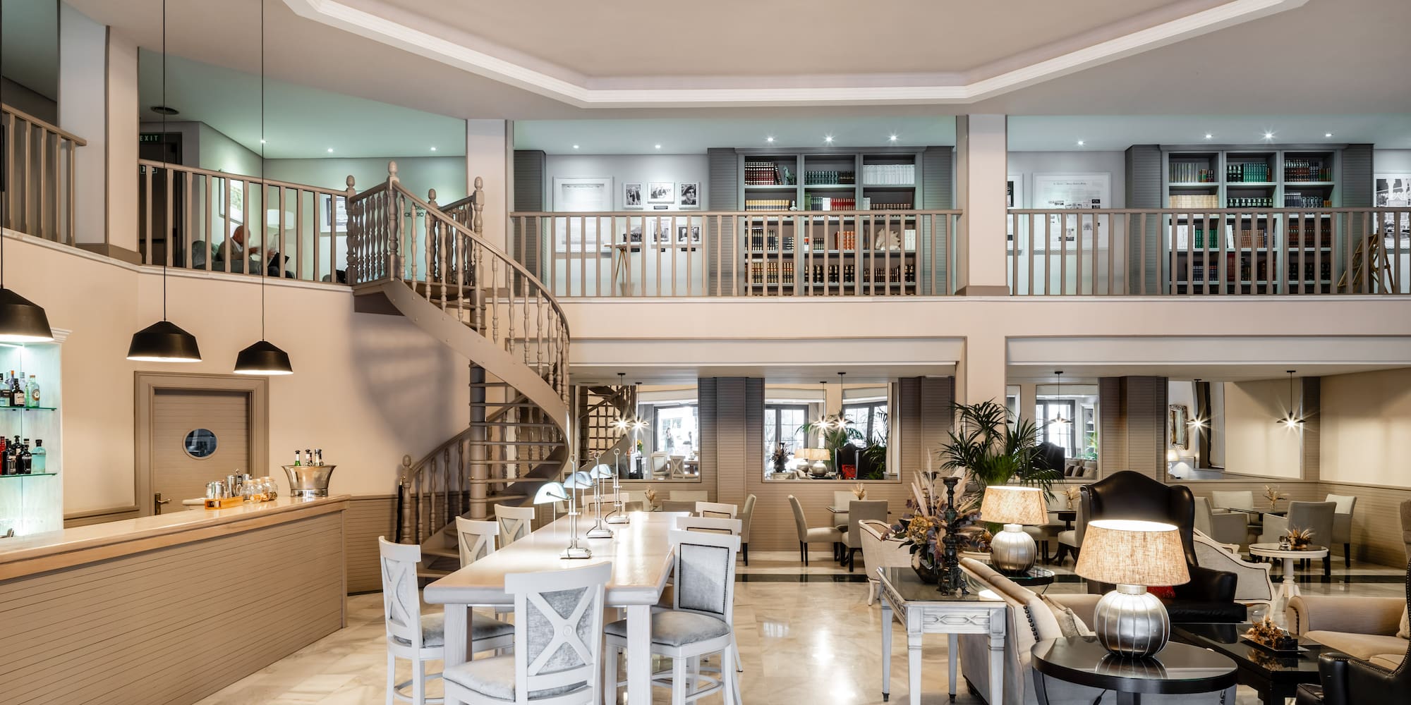 a room with a spiral staircase and a large table and chairs