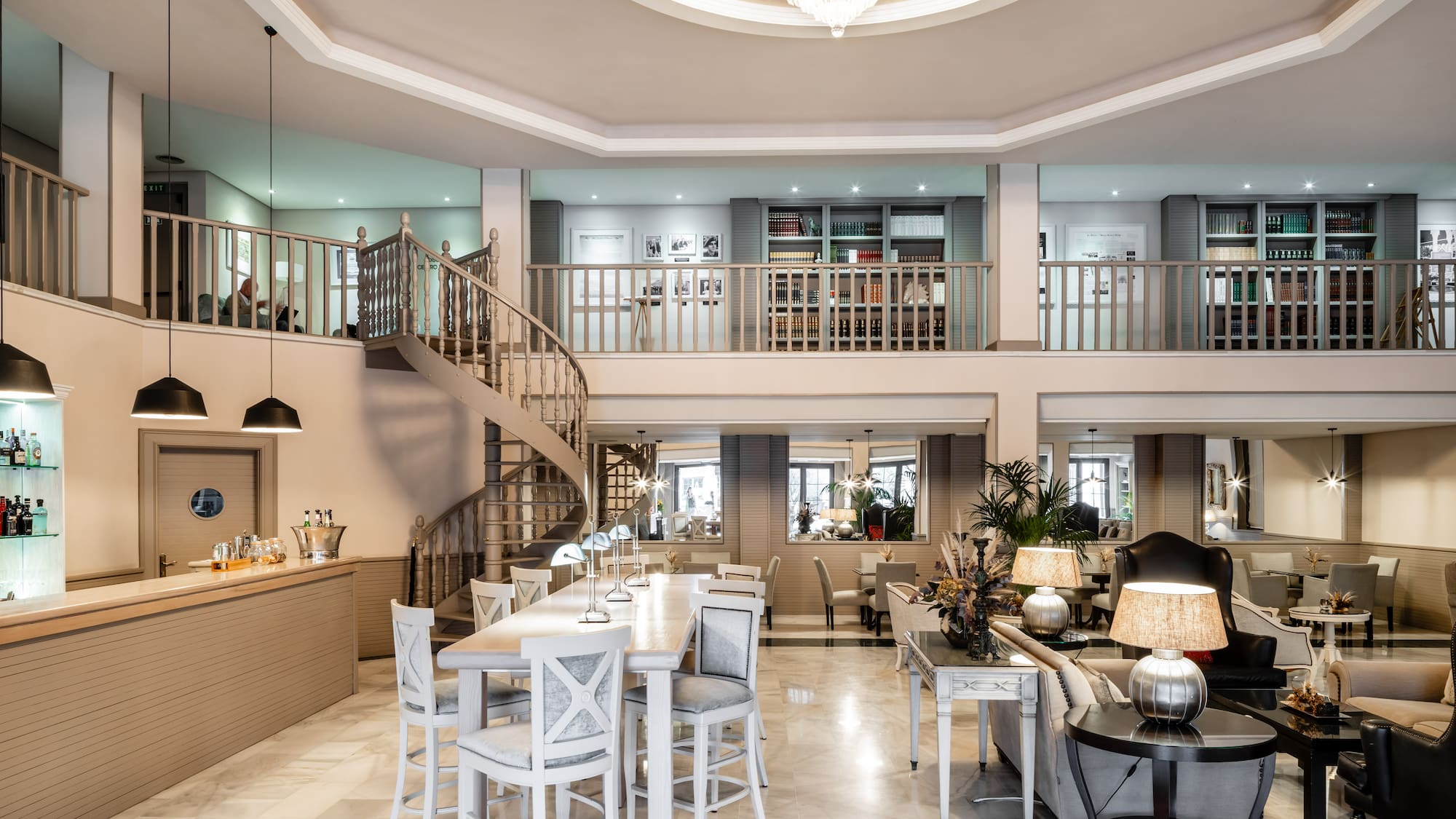 a room with a spiral staircase and a large table and chairs