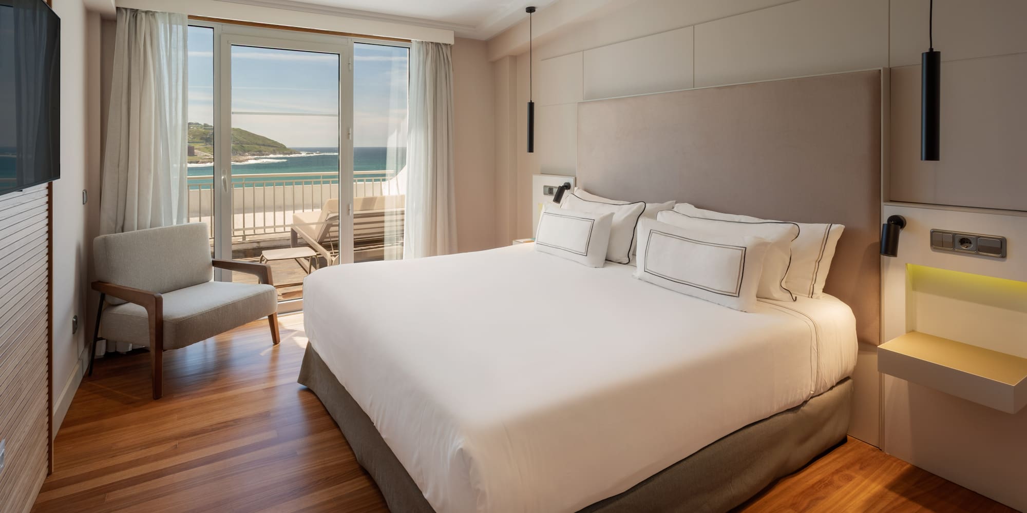 a bedroom with a large bed and a chair