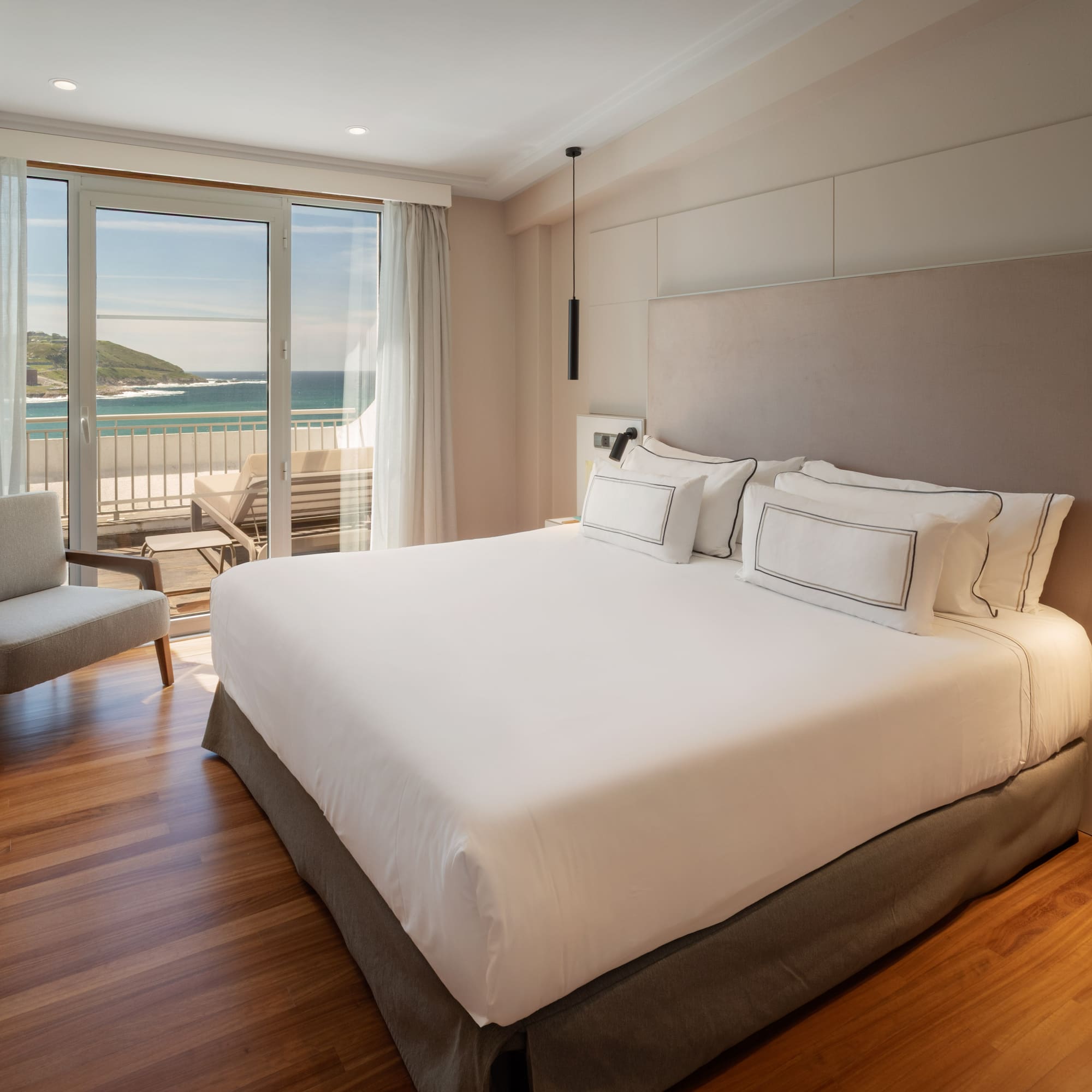 a bedroom with a large bed and a chair