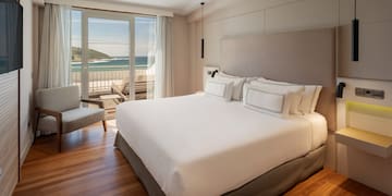 a bedroom with a large bed and a chair