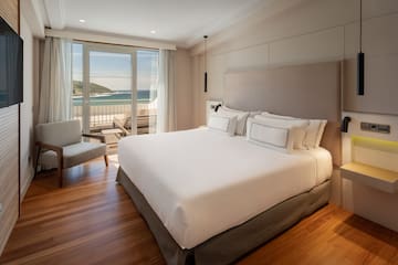 a bedroom with a large bed and a chair