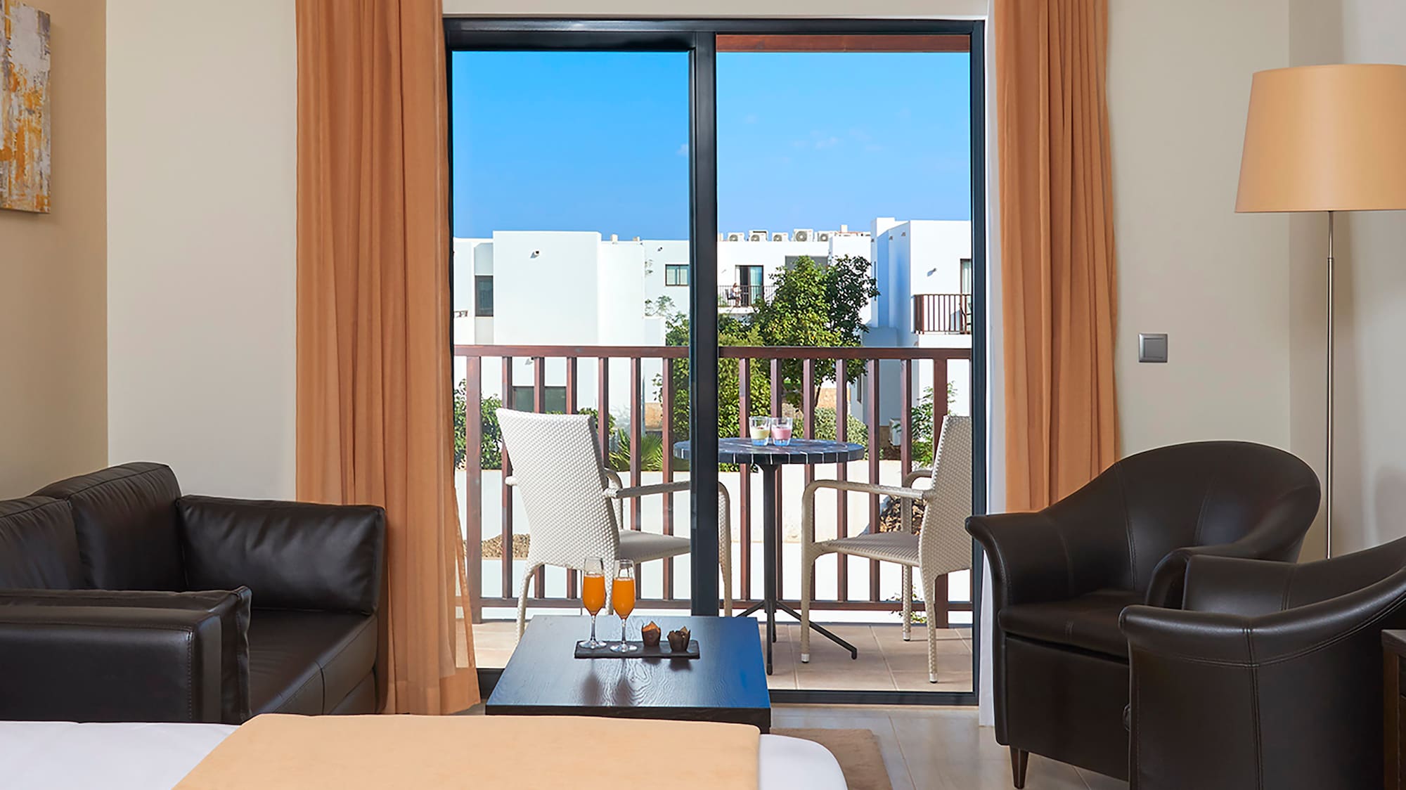 a room with a bed and chairs and a table