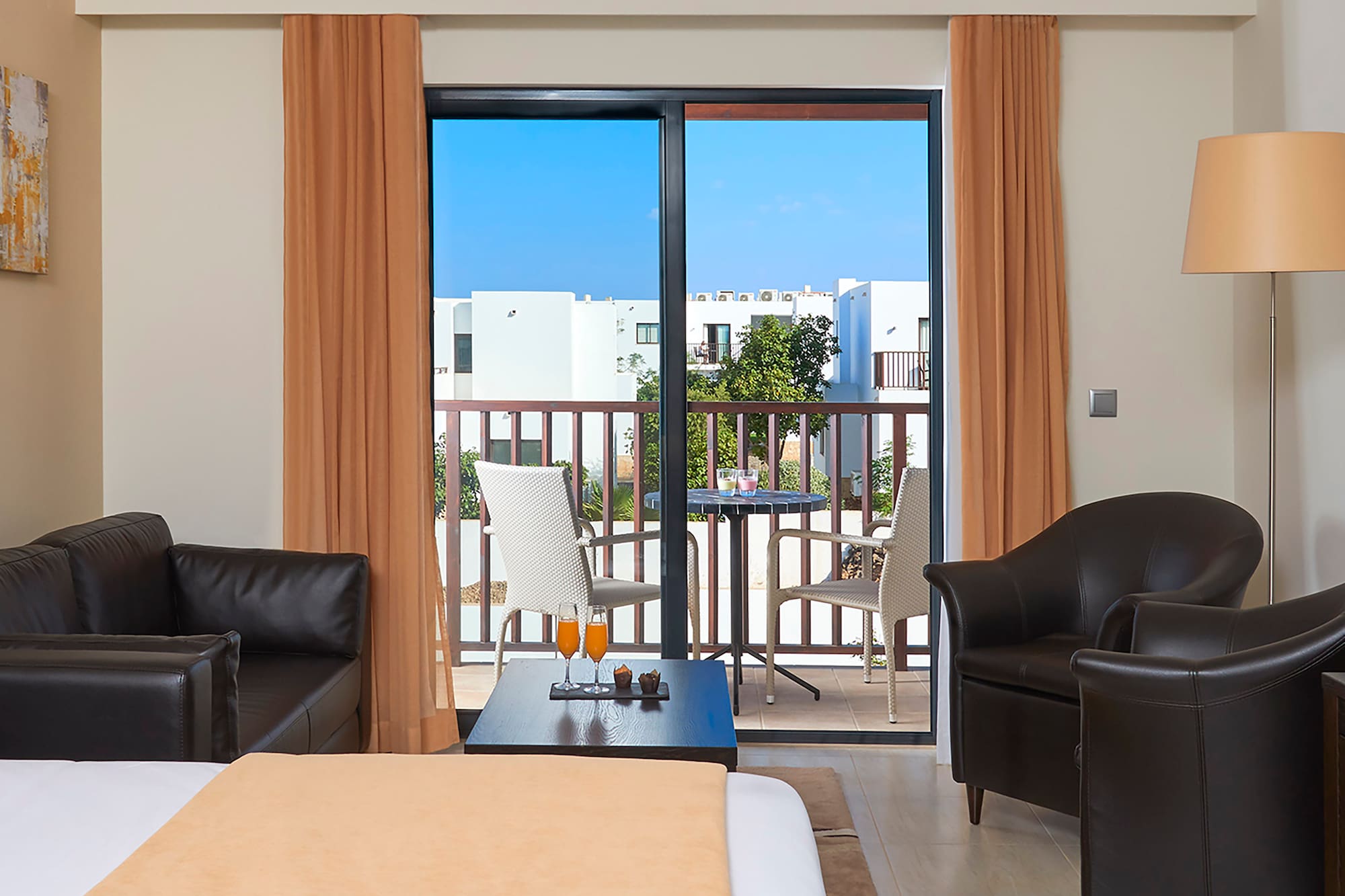 a room with a bed and chairs and a table