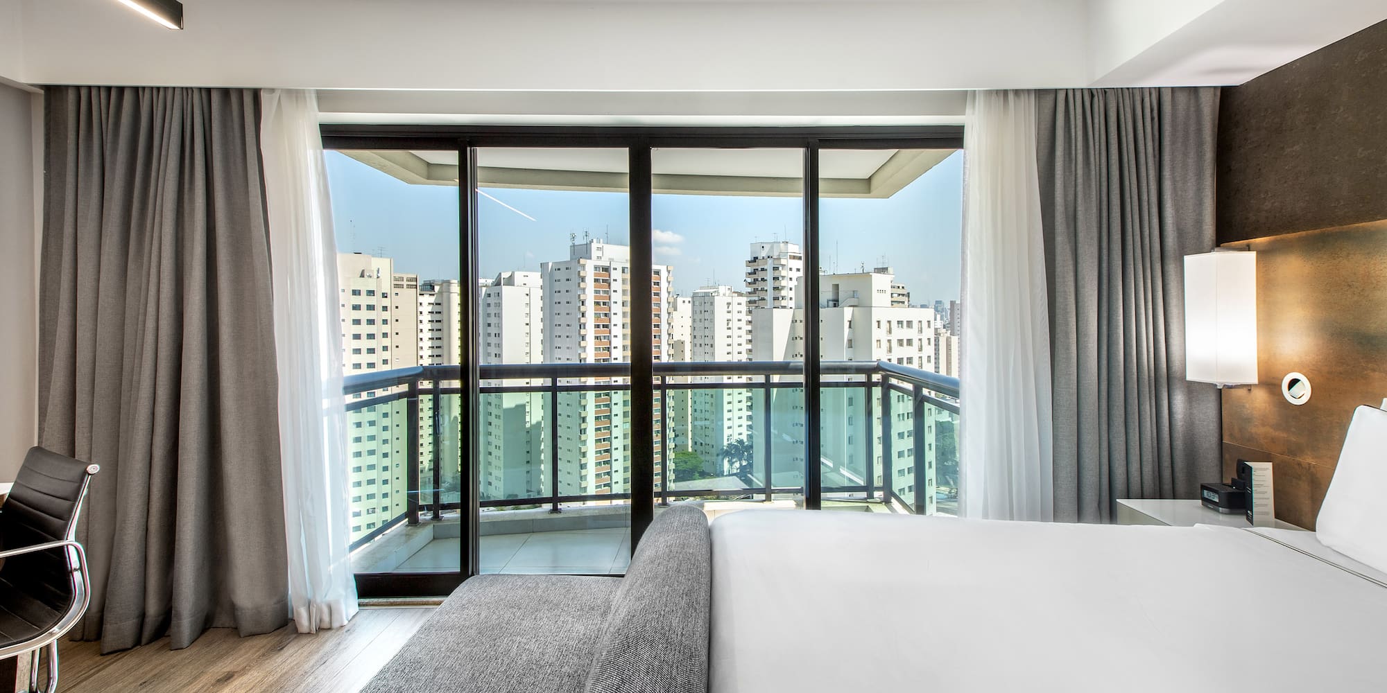 a bedroom with a large window and a couch