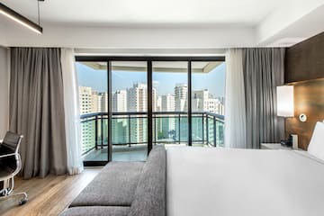 a bedroom with a large window and a couch