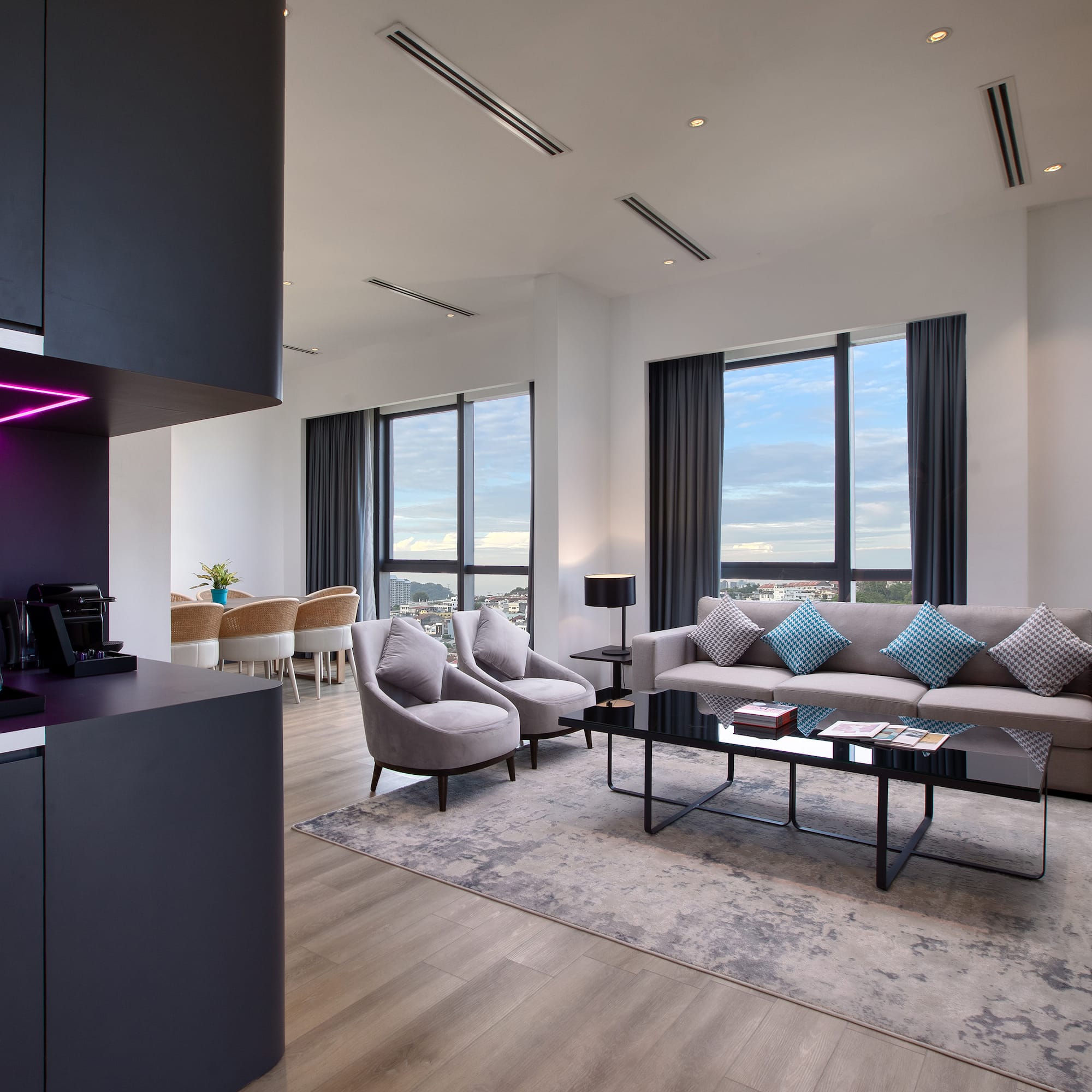 a room with a black counter top and a black cabinet and a couch and chairs