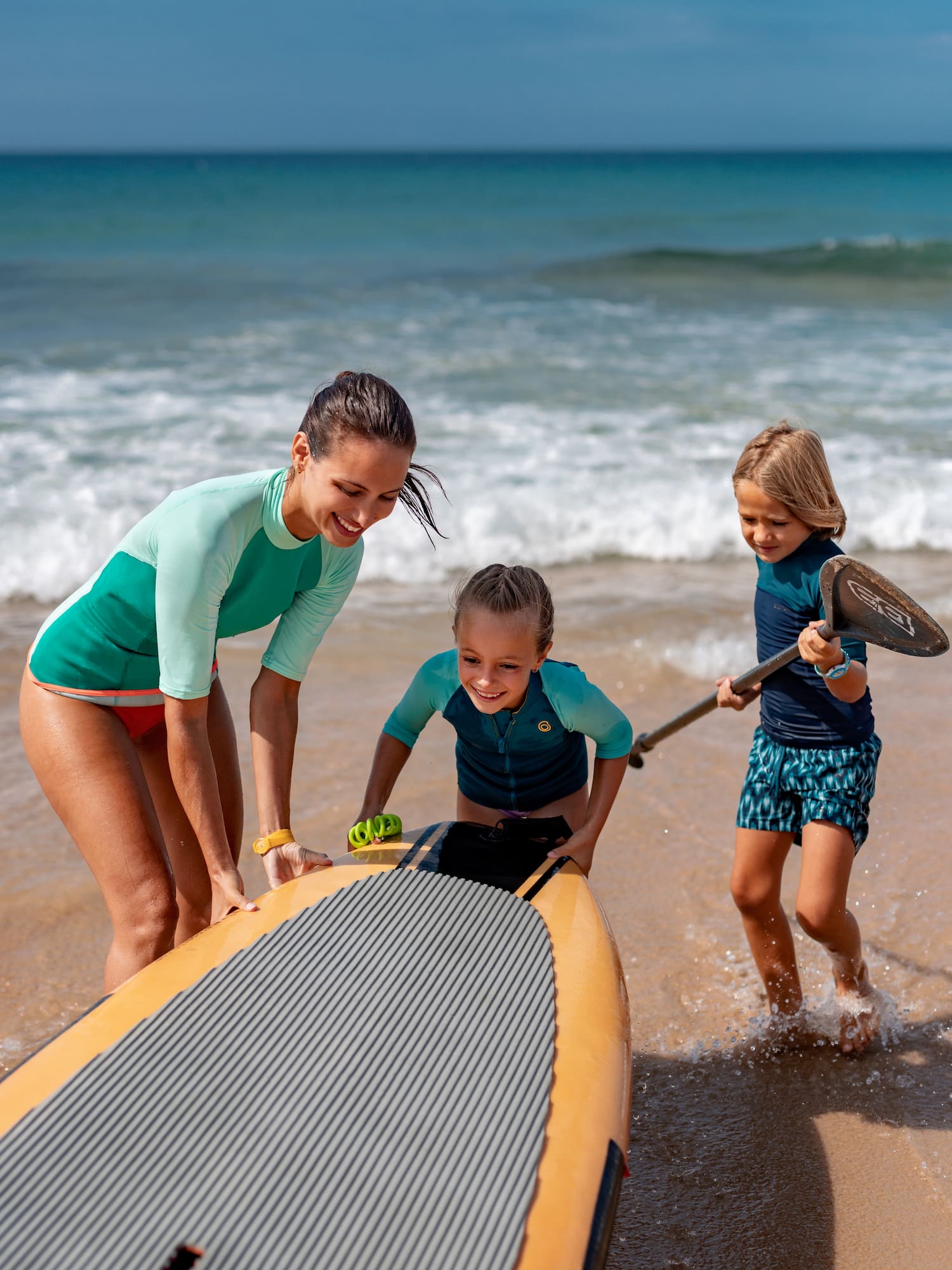 a woman and two girls on a beach
