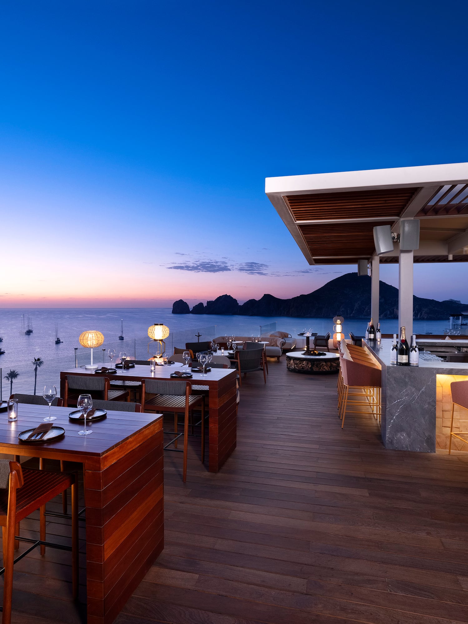 a restaurant with tables and chairs on a deck overlooking water