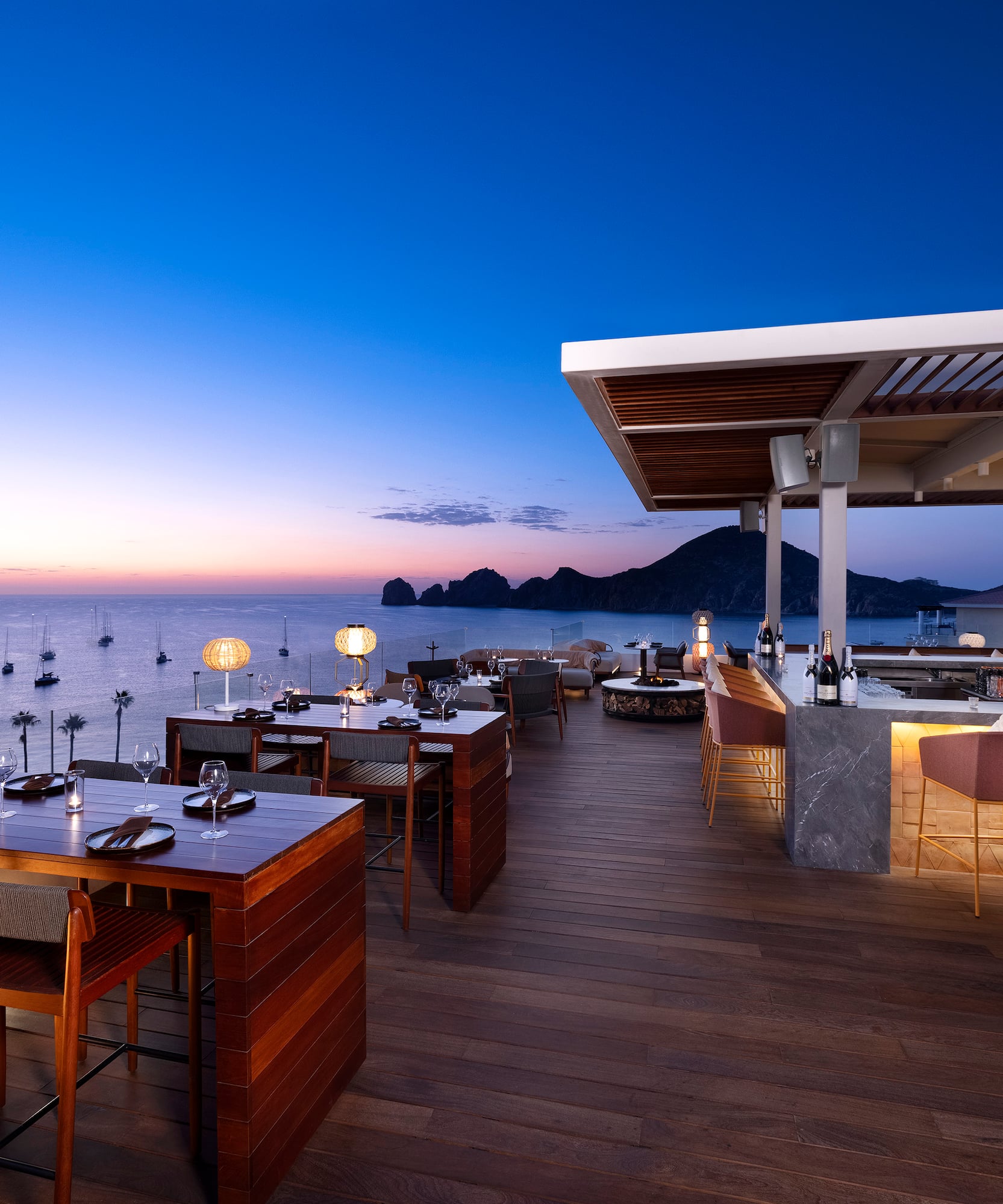 a restaurant with tables and chairs on a deck overlooking water