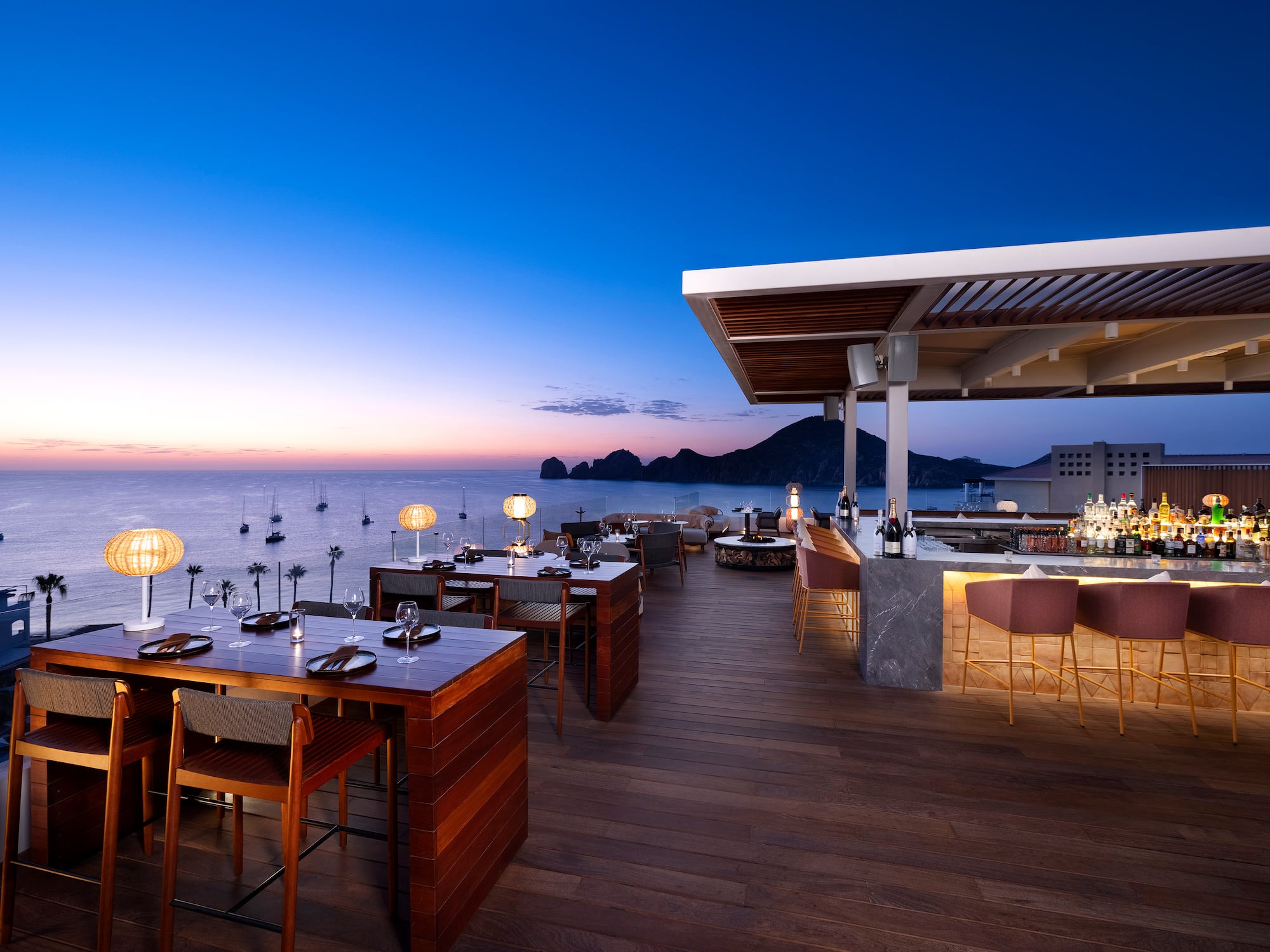 a restaurant with tables and chairs on a deck overlooking water