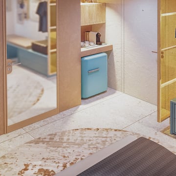 a room with a mirror and a blue refrigerator