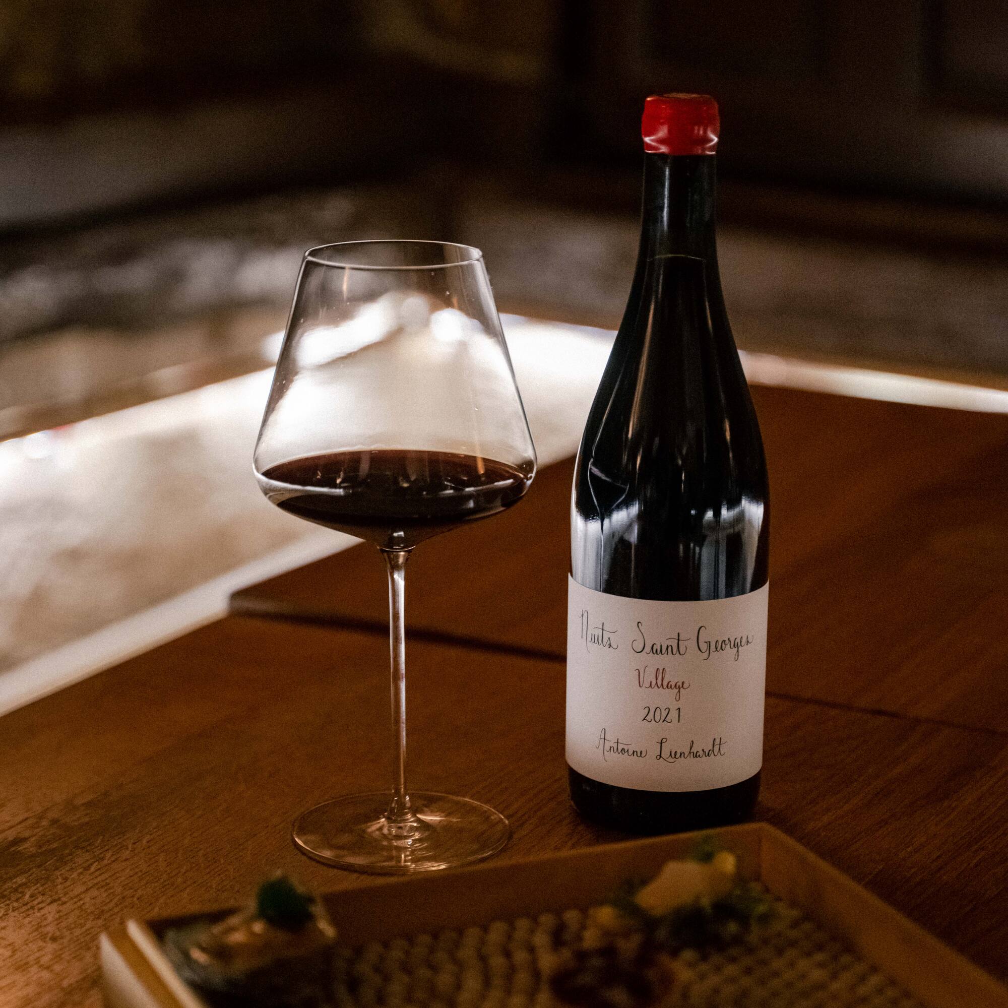 a bottle and glass of wine on a table