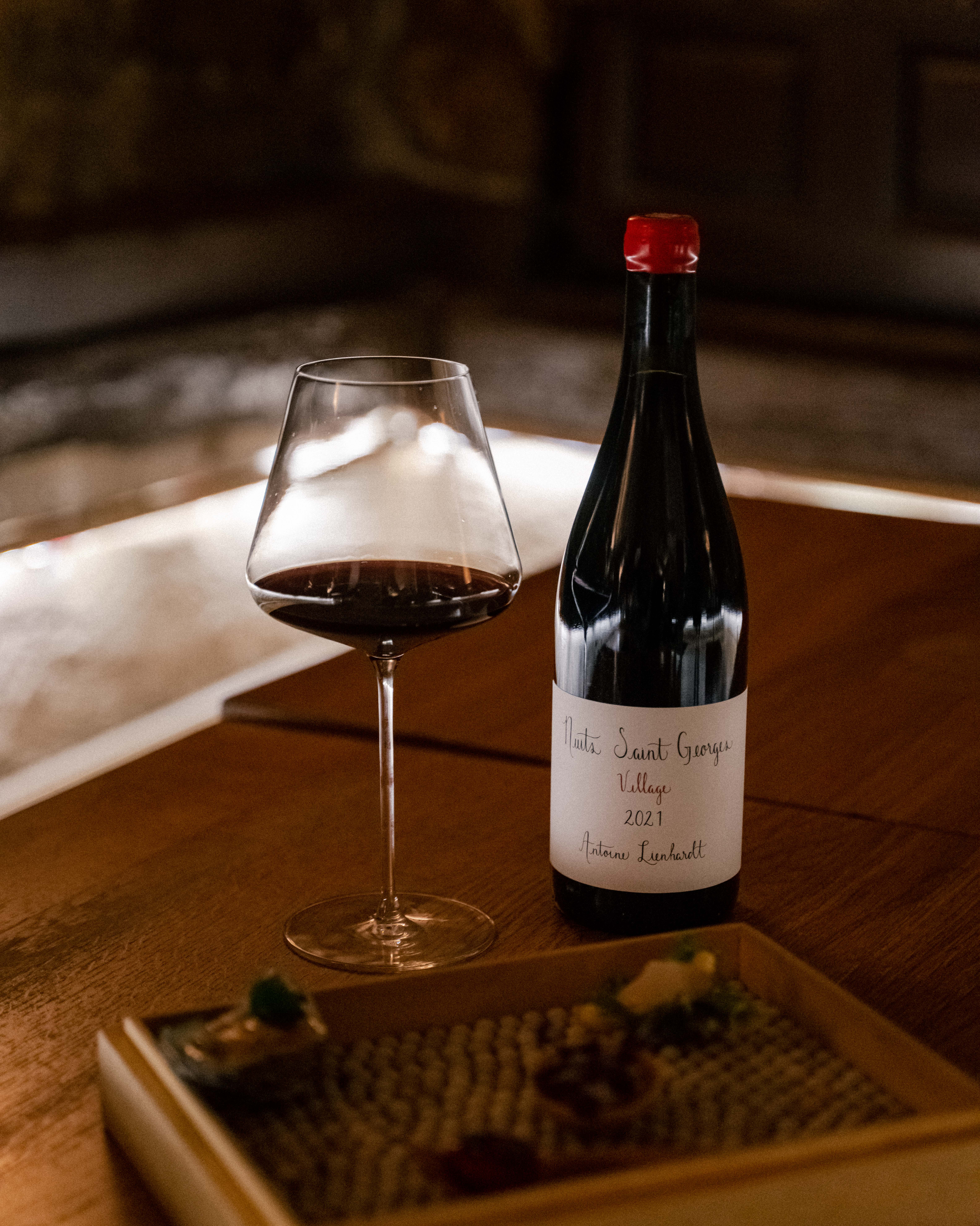 a bottle and glass of wine on a table