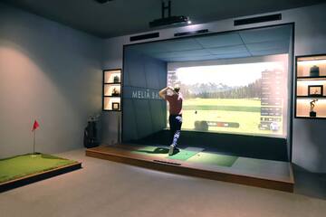 a man playing golf in a room