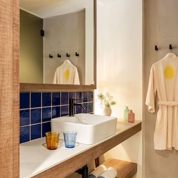 a bathroom with a white sink and blue tile wall