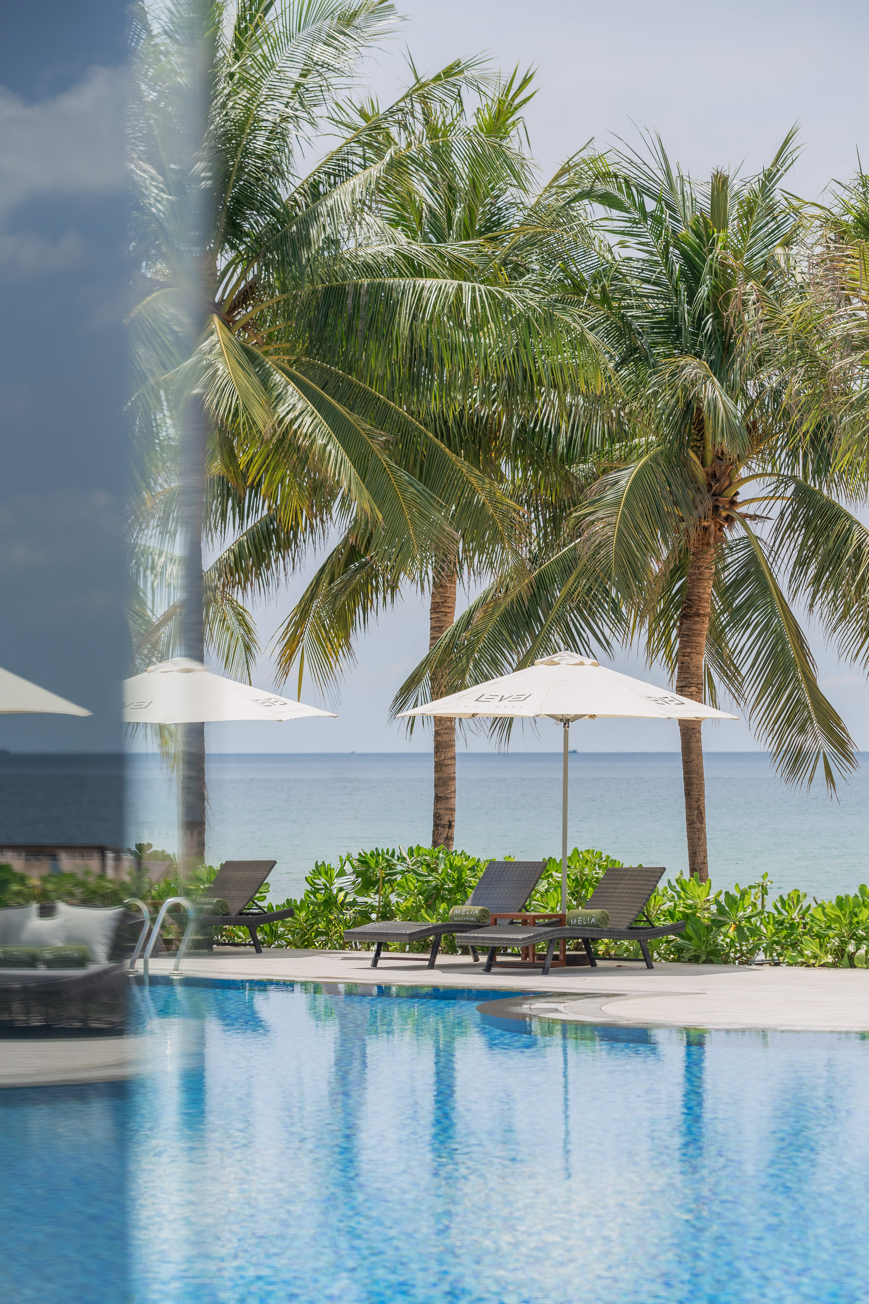 a pool with umbrellas and chairs by the water
