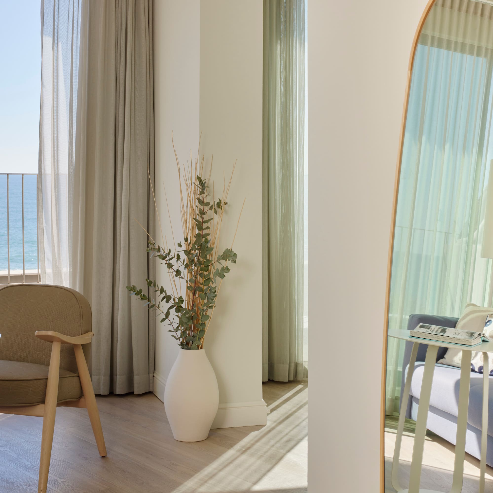 a room with a large mirror and a plant in a vase