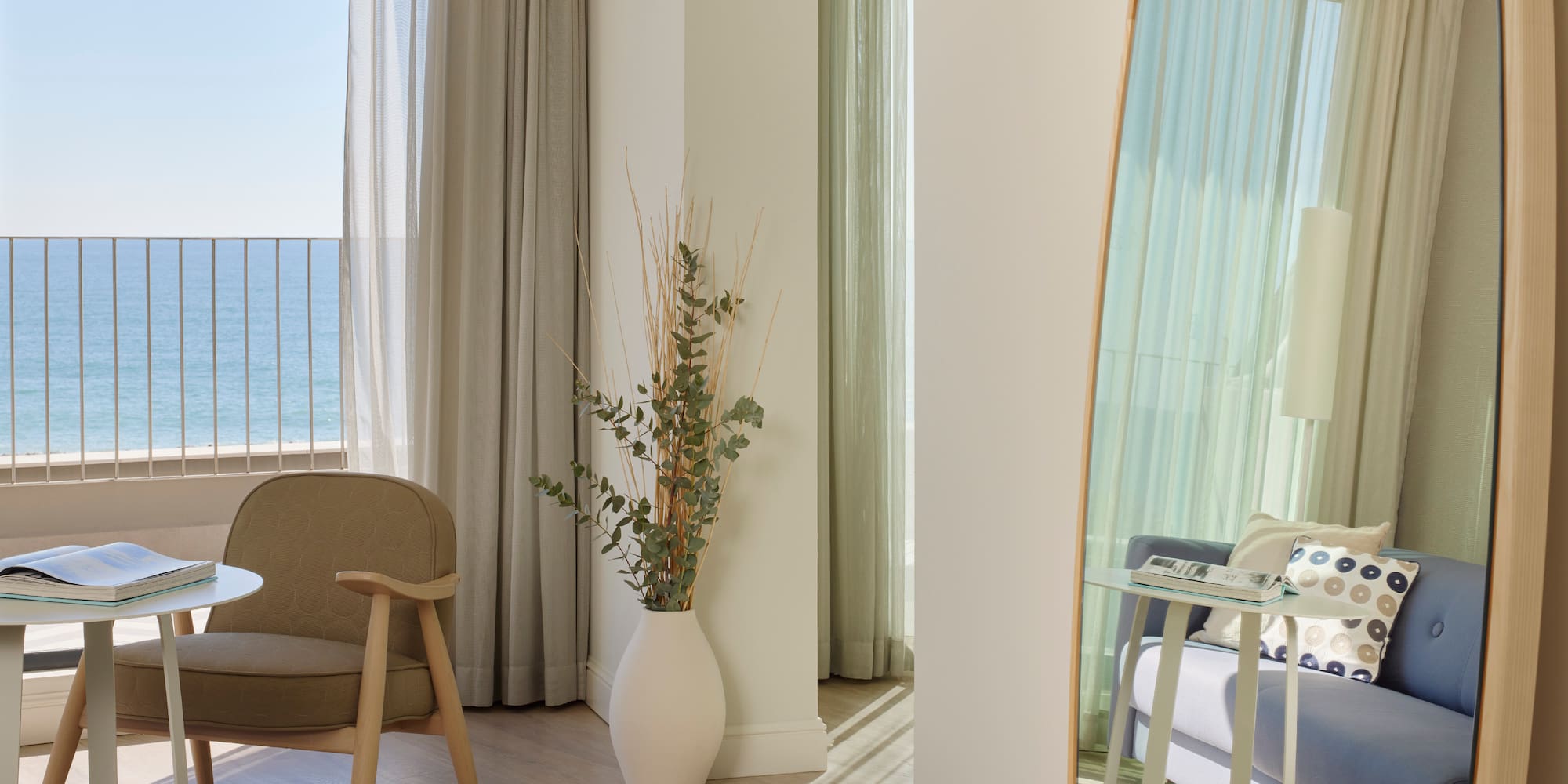 a room with a large mirror and a plant in a vase