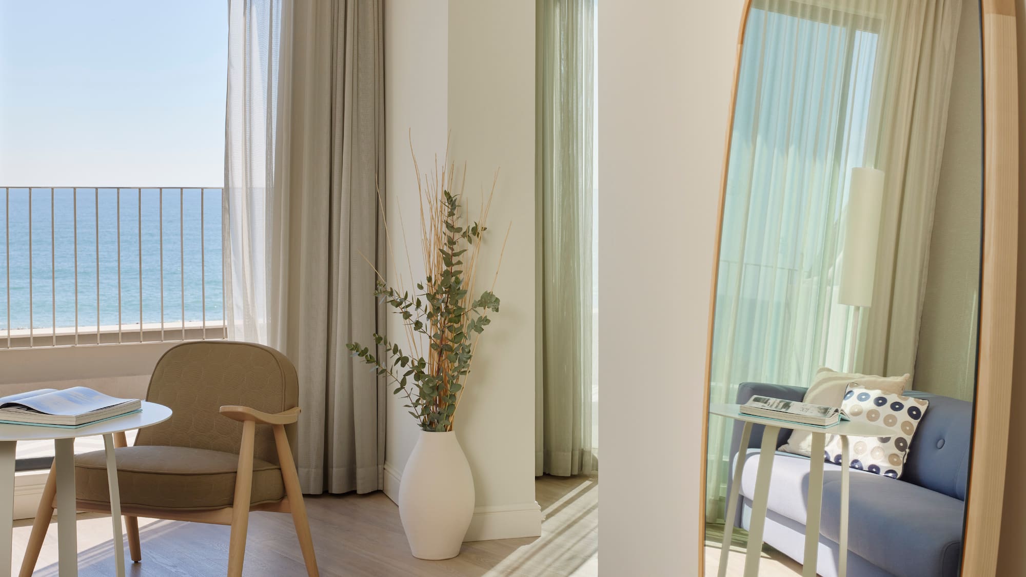 a room with a large mirror and a plant in a vase