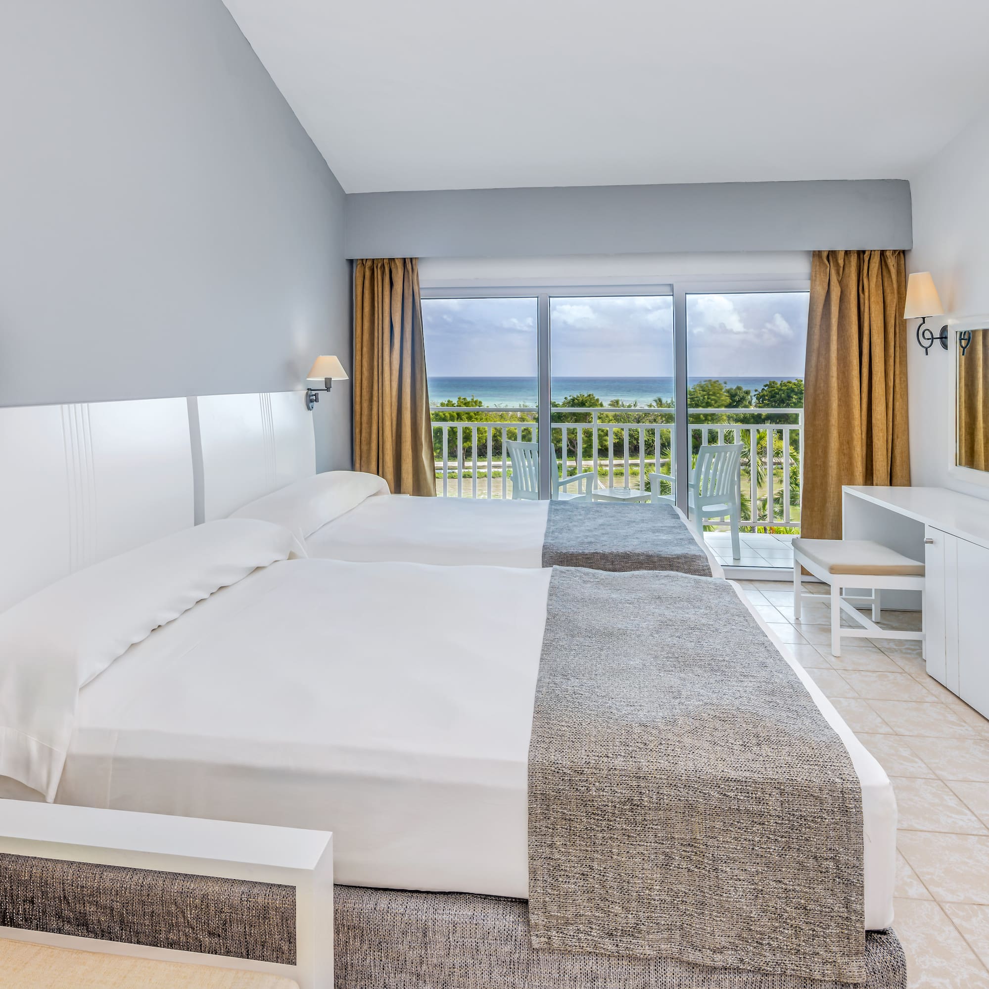 a room with two beds and a balcony