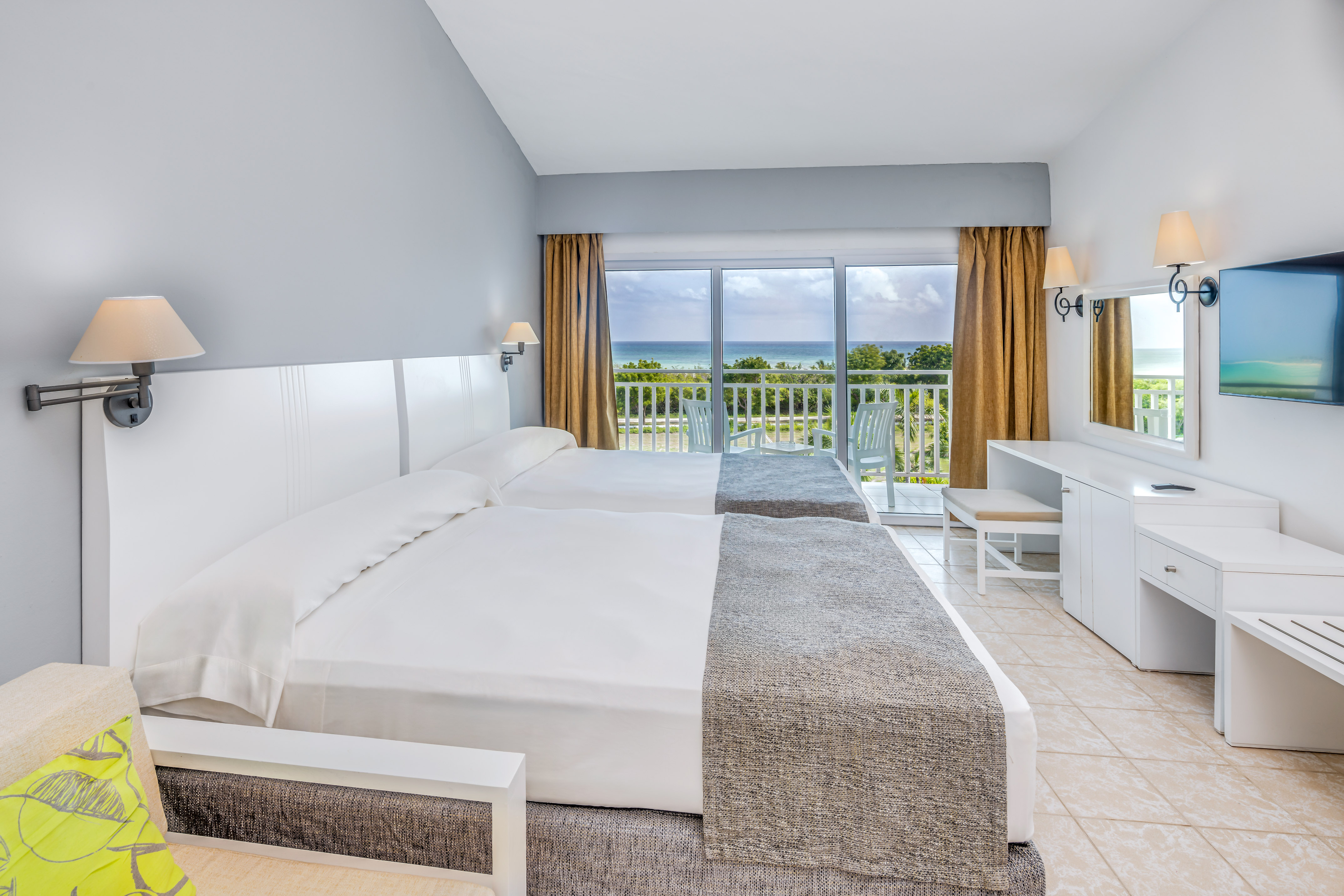 a room with two beds and a balcony