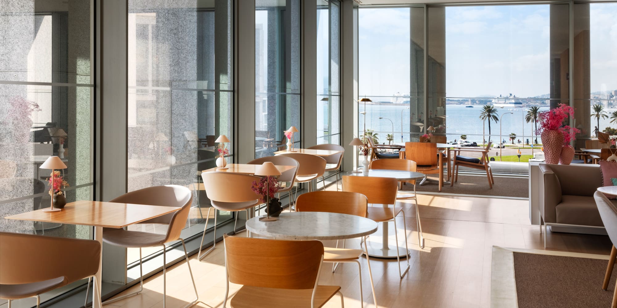 a room with tables and chairs and a view of the water