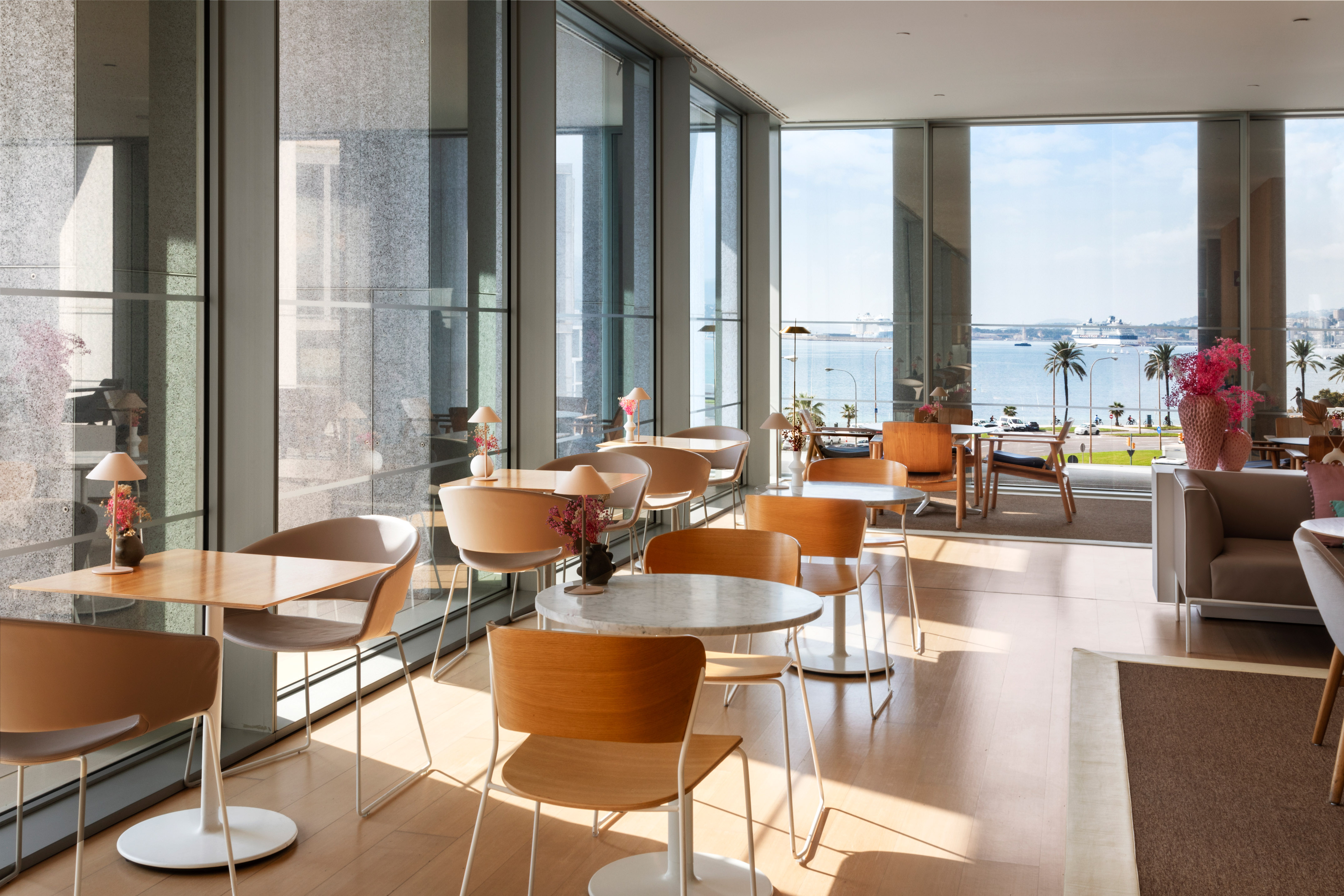 a room with tables and chairs and a view of the water