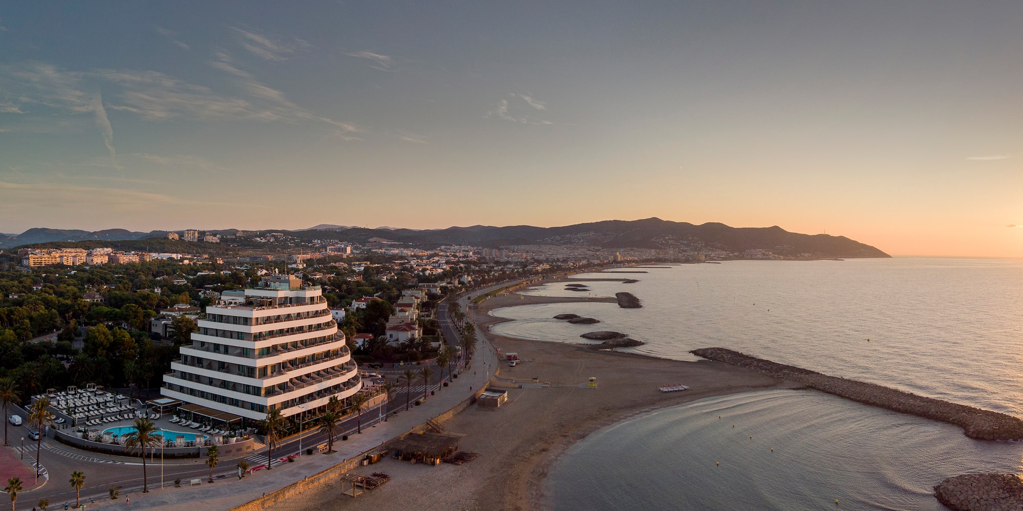 a beach with a large building and a body of water