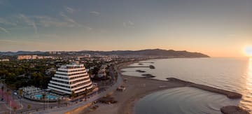 a beach with a large building and a body of water