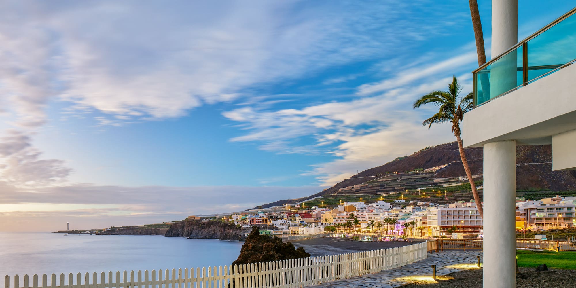 a white fence next to a beach