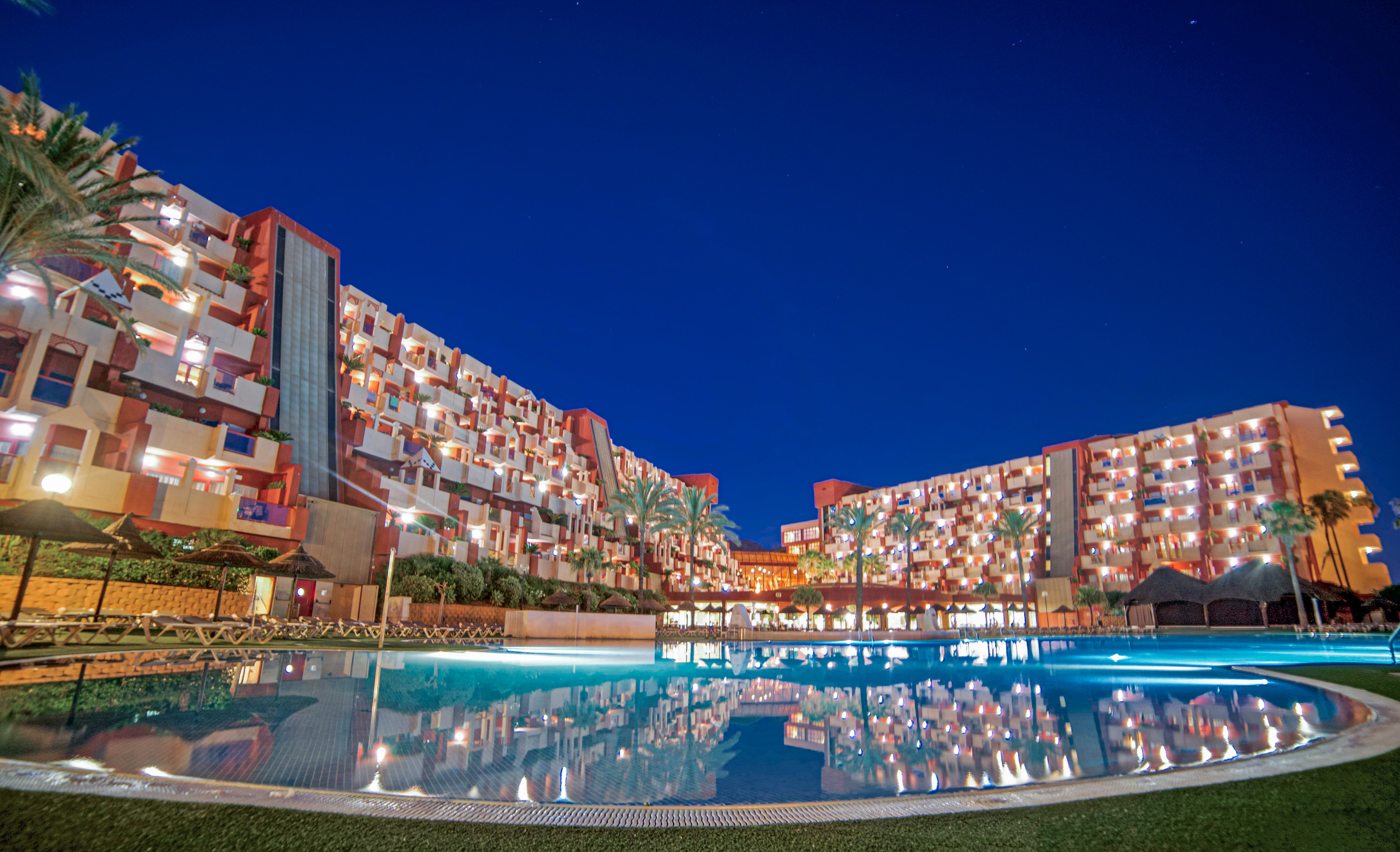a pool with lights on the building