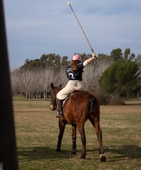 a woman on a horse with a stick