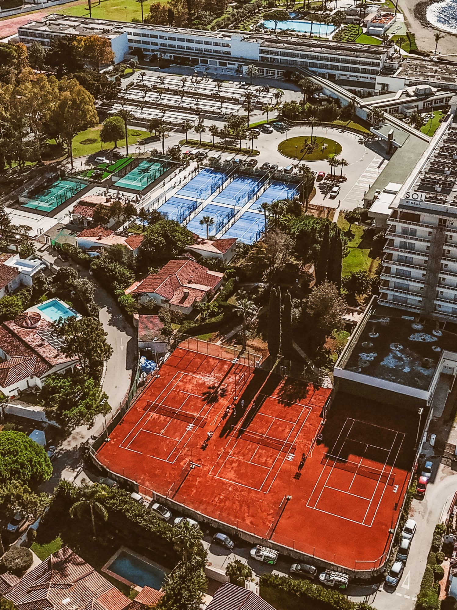 an aerial view of a tennis court and swimming pool