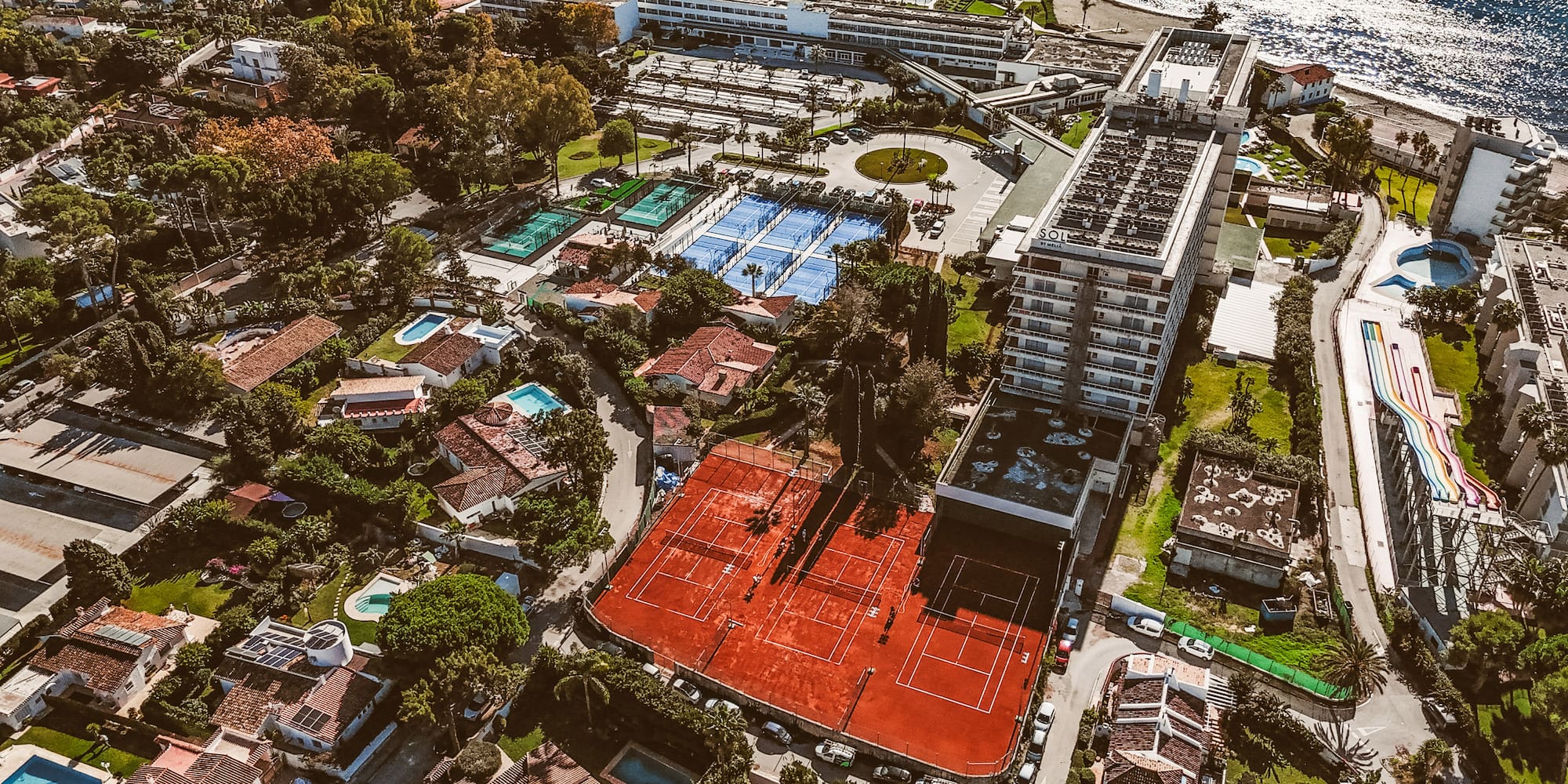 an aerial view of a tennis court and swimming pool