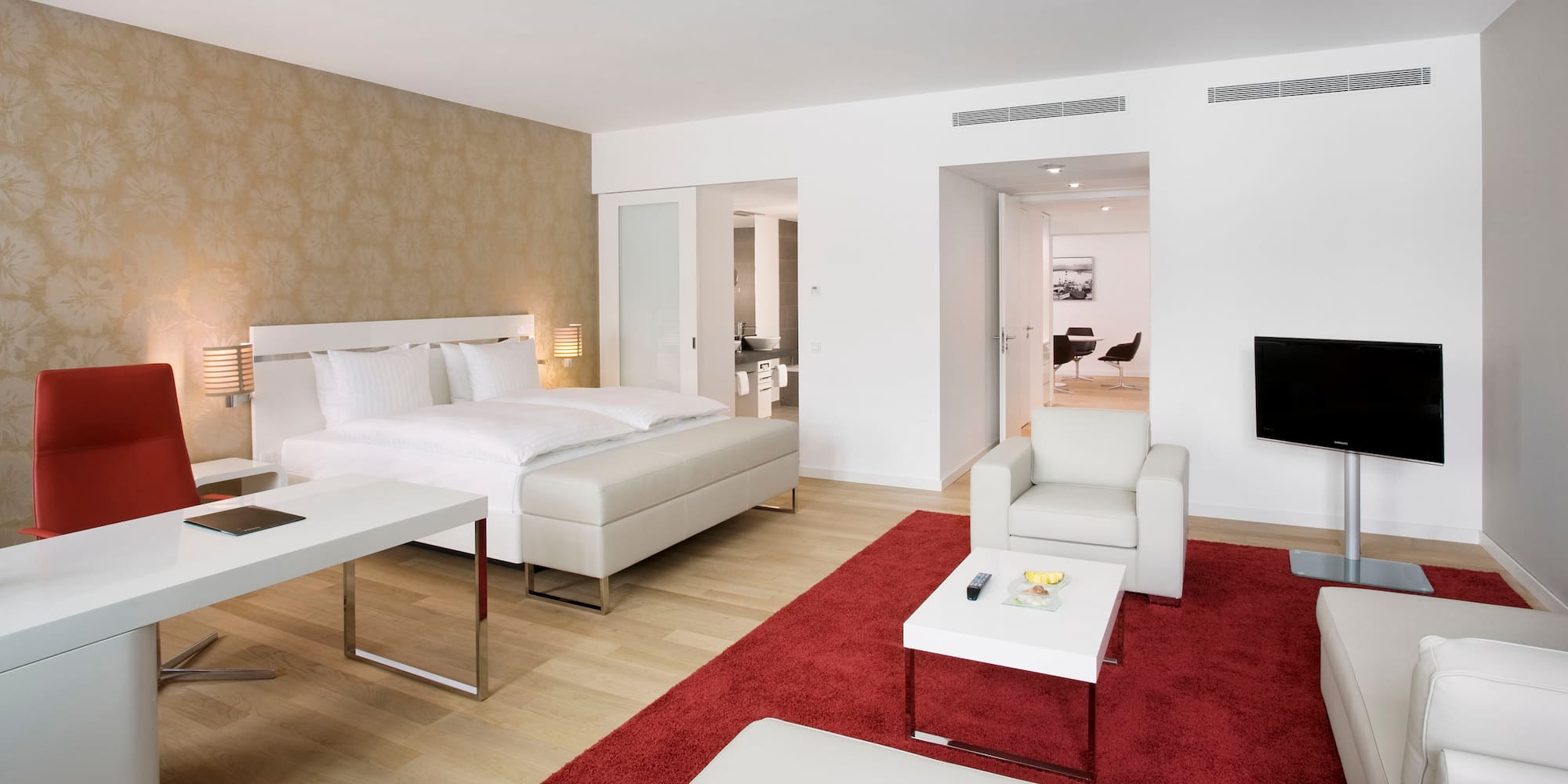 a bedroom with a red rug and white furniture