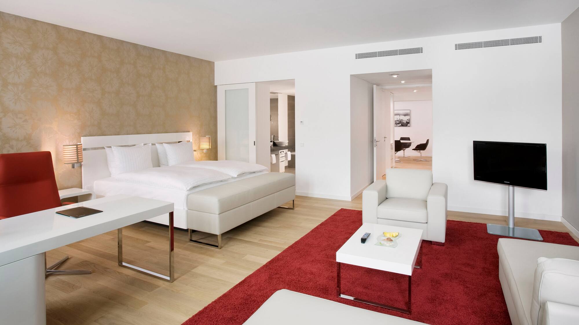 a bedroom with a red rug and white furniture