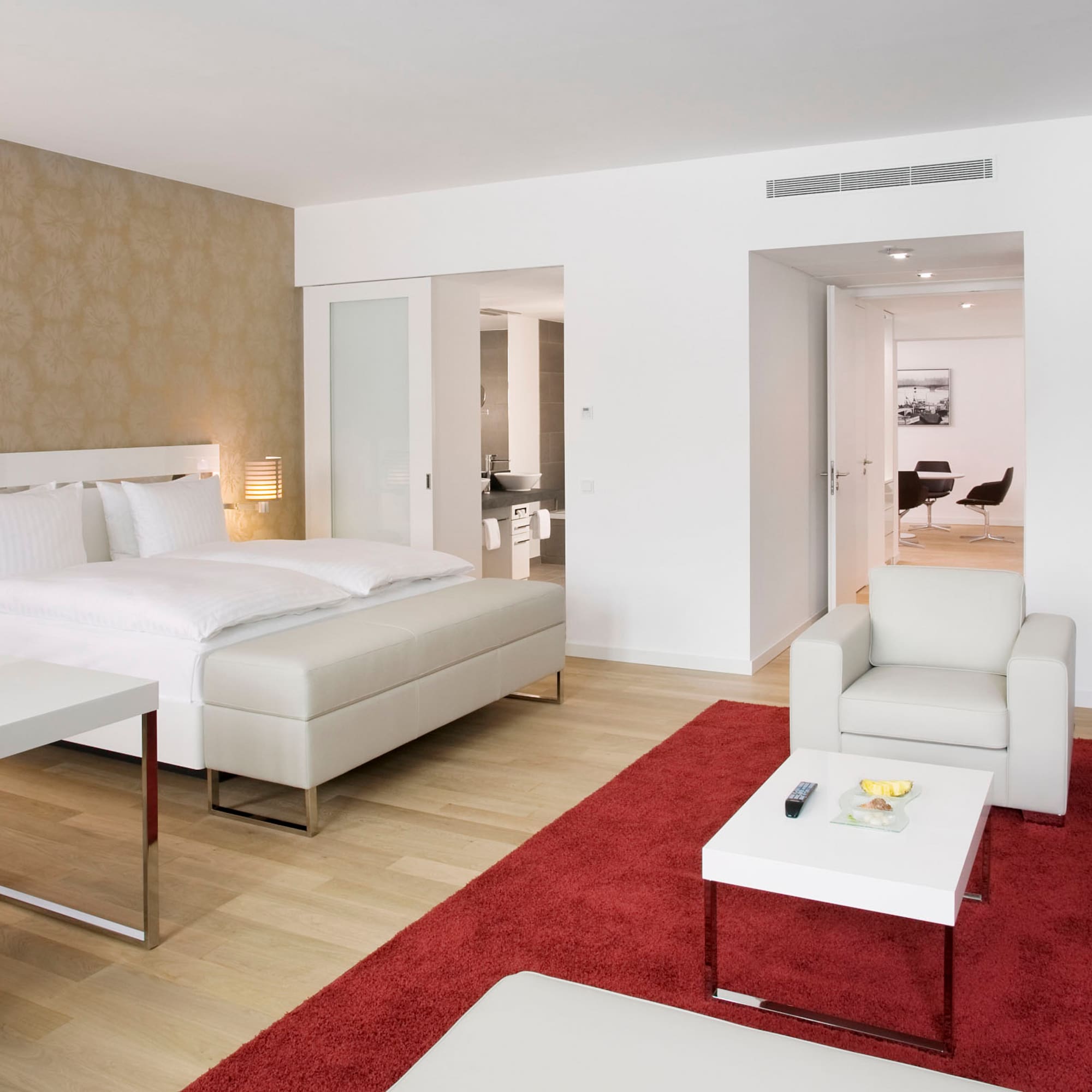 a bedroom with a red rug and white furniture