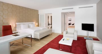 a bedroom with a red rug and white furniture
