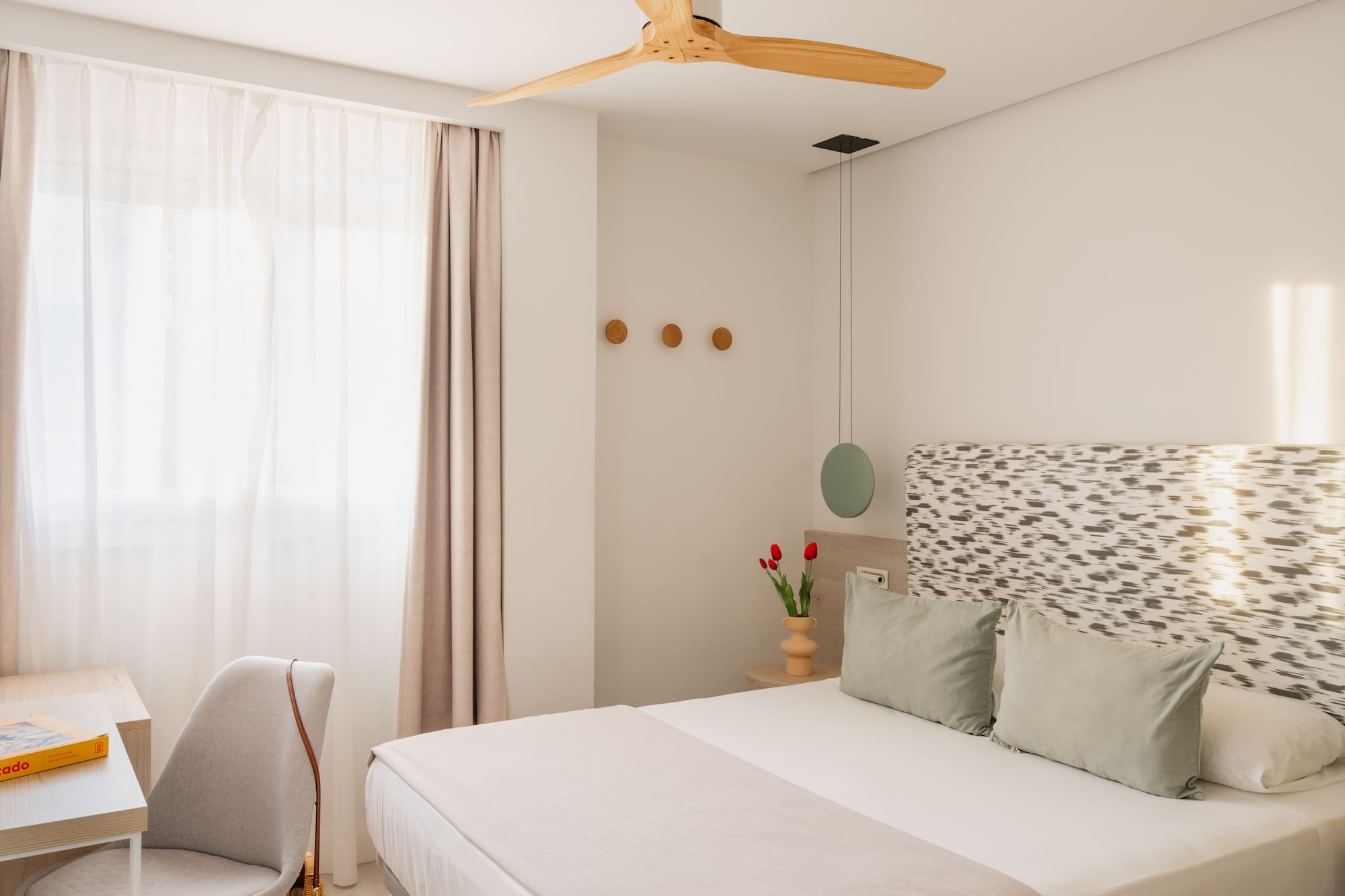 a bedroom with a fan and a bed