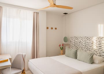 a bedroom with a fan and a bed