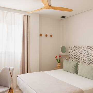 a bedroom with a fan and a bed