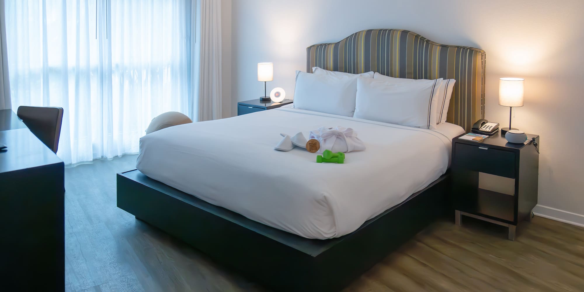 a bed with a white bedding and a table with lamps