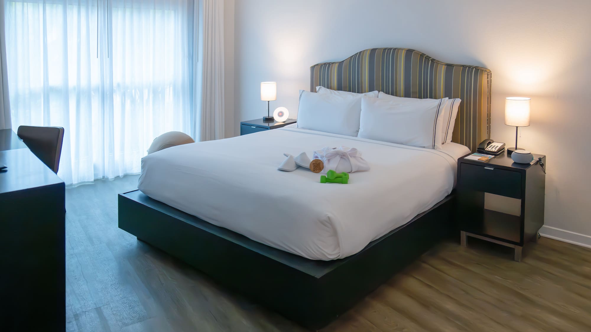 a bed with a white bedding and a table with lamps