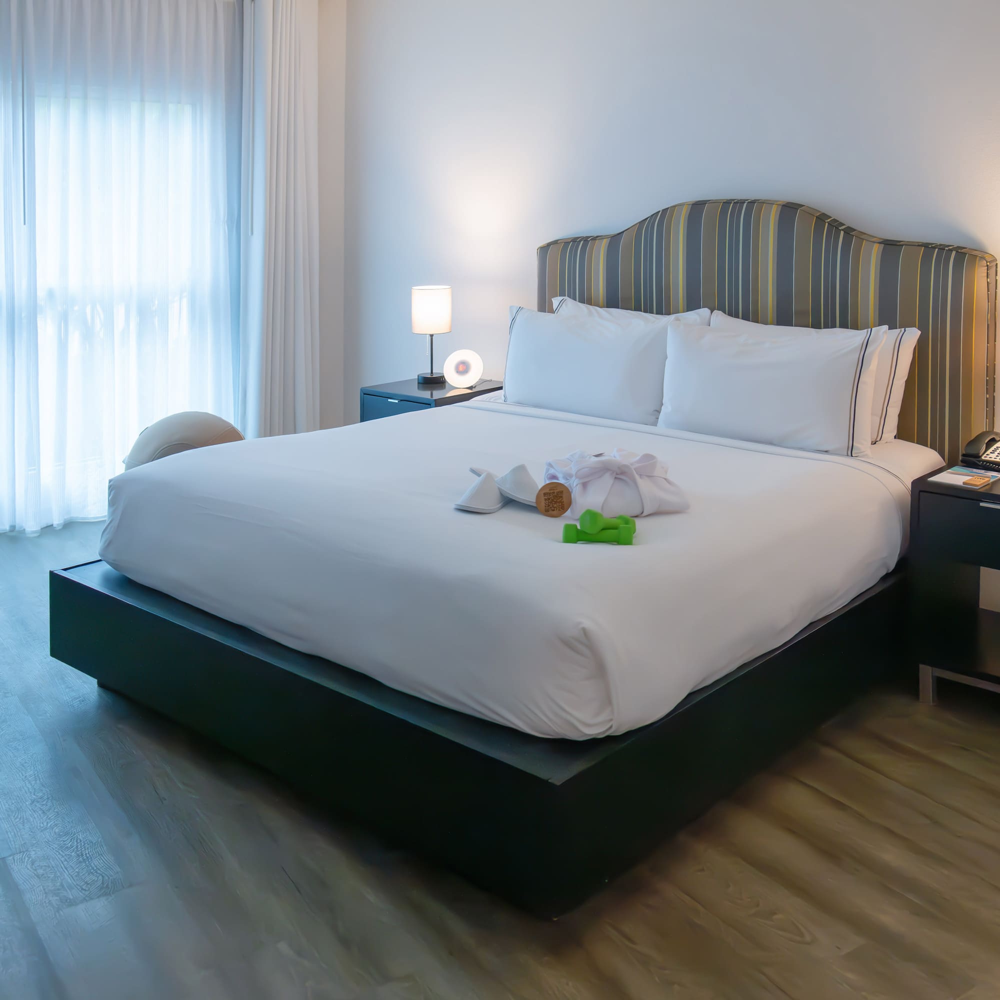 a bed with a white bedding and a table with lamps