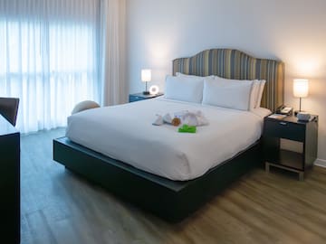 a bed with a white bedding and a table with lamps