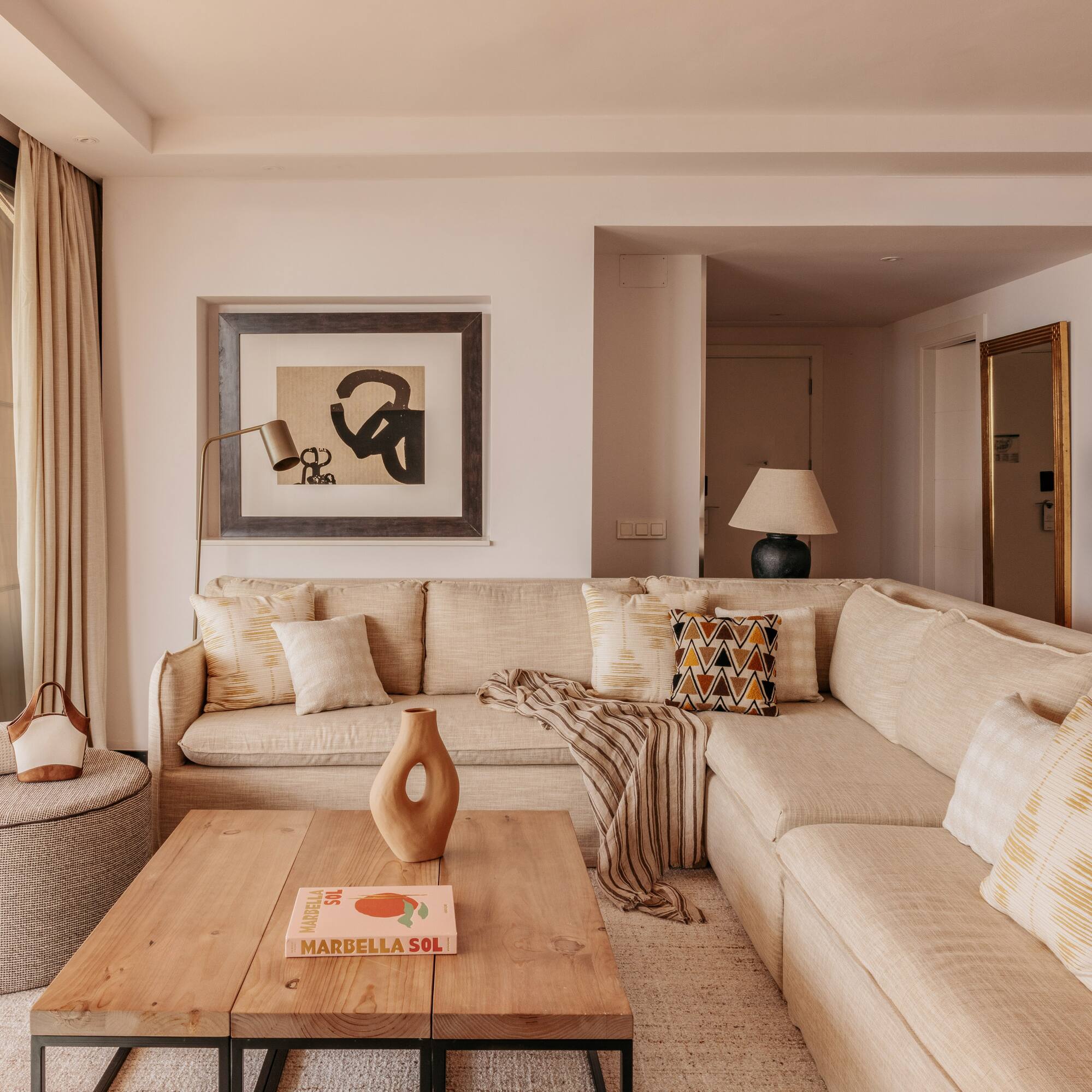 Neutral modern living room with large sectional sofa, coffee table, and art.