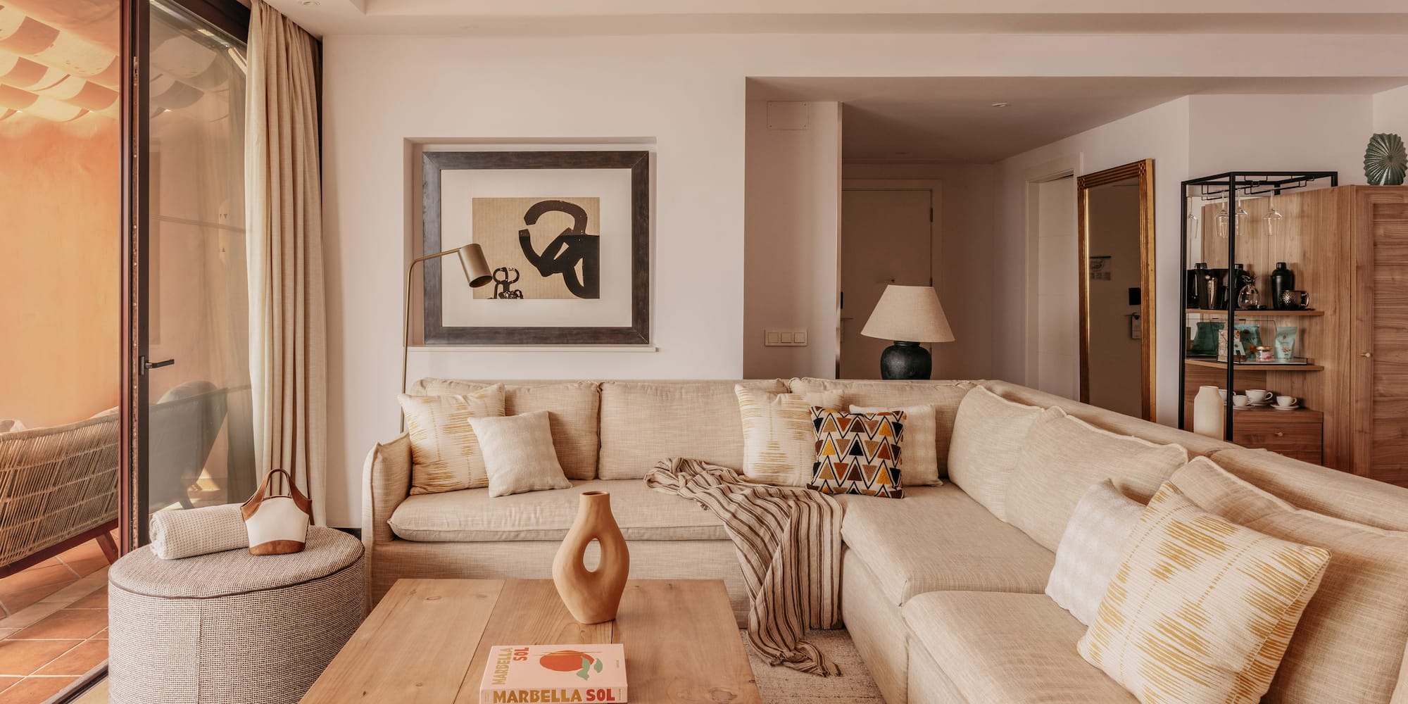 Neutral modern living room with large sectional sofa, coffee table, and art.
